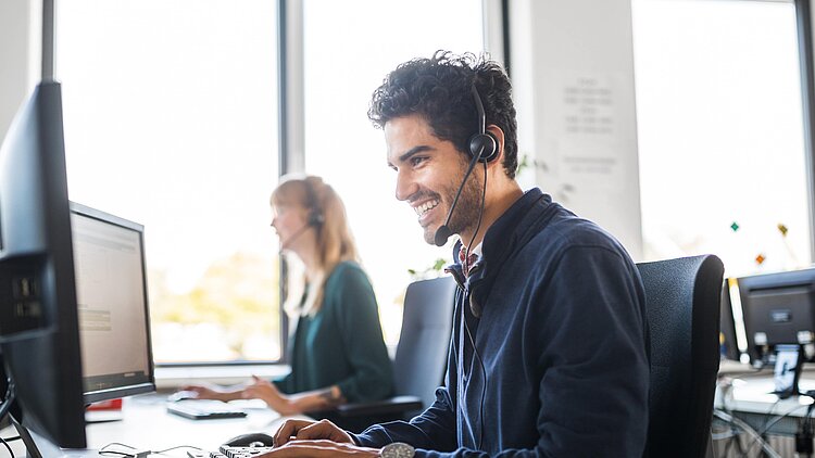 Foto: Mann mit Headset im Büro
